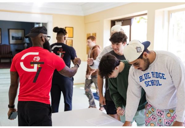 A group of young men interacting indoors around a table.
