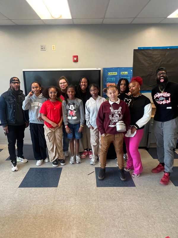 A group of diverse people posing together indoors with smiles and casual attire.
