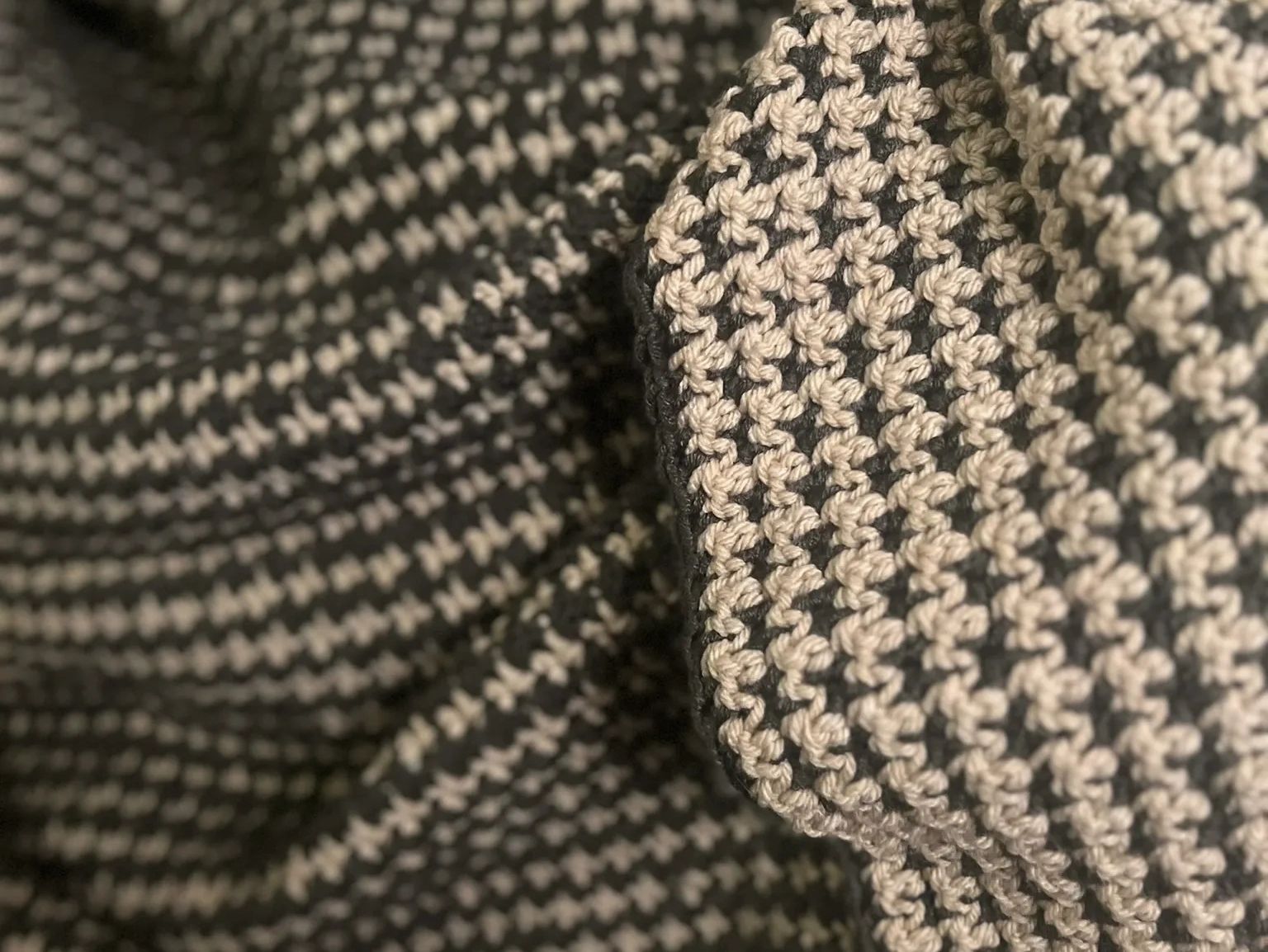 Two‑tone textured crochet houndstooth fabric with soft drape and high‑contrast detail.