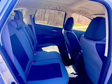 Backseat interior of a car with blue and black seats in daylight.