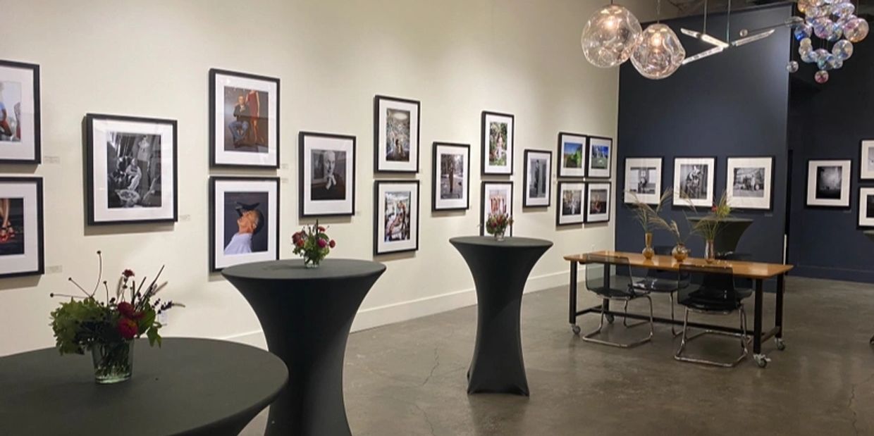 Photography exhibition with framed photos and decorated tables.