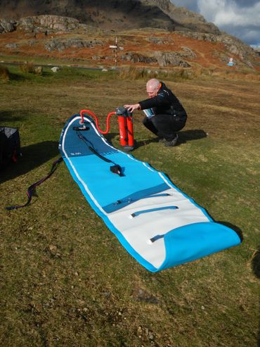 Customer reading the instructions on how to inflate our Red paddle boards.