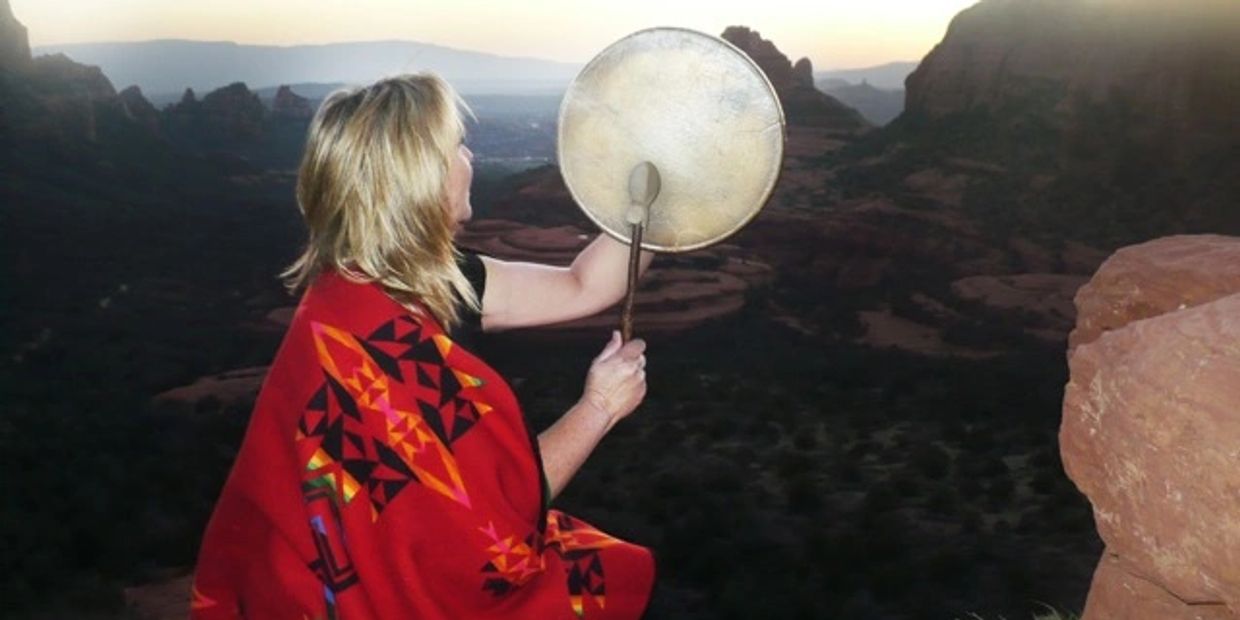 A woman sitting on a red rock