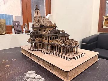 Intricate wooden architectural model of a temple on a table.