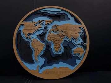 Intricately layered wooden world map with oceanic depth details.
