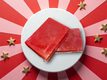 Picture of red soaps with pumice inside them stacked on one another.