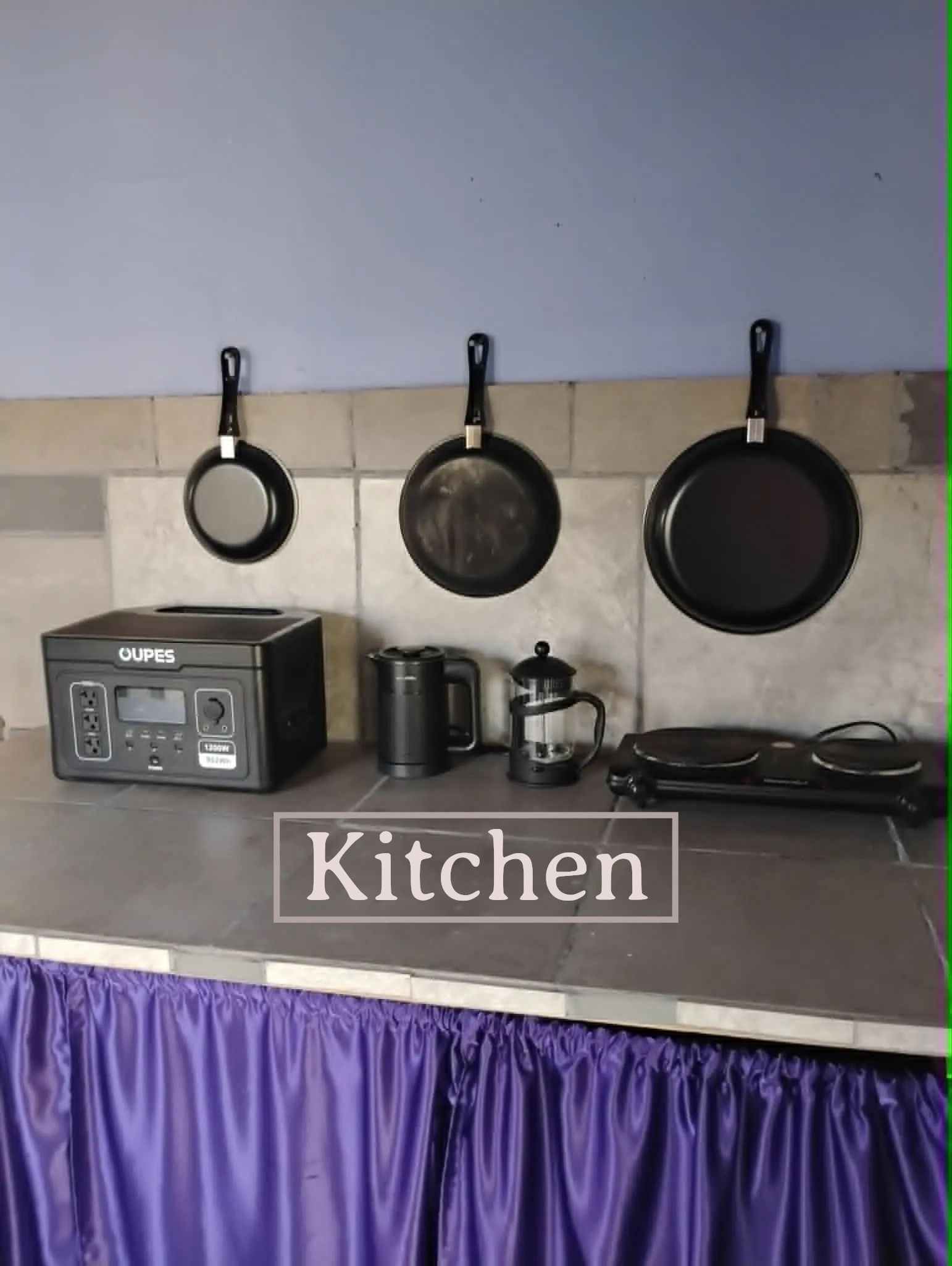 A neat kitchen setup with hanging pans and appliances on the counter.