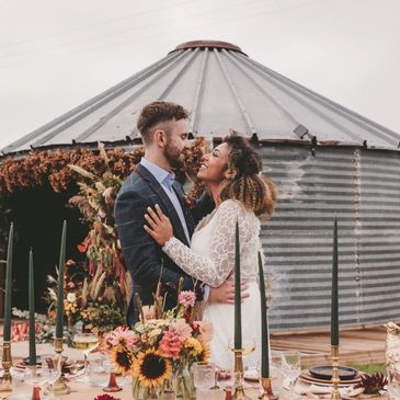 a couple smiling whilst looking at each other in front of a beautiful table