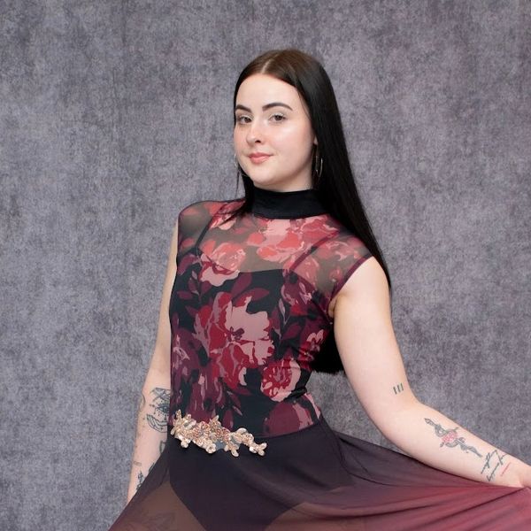Young woman in a floral dress posing gracefully.