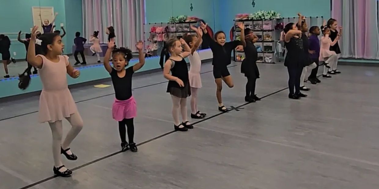 Young children practicing ballet in a dance studio.