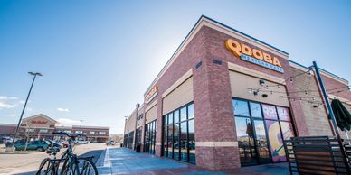 Exterior view of a QDOBA Mexican Eats restaurant on a sunny day.