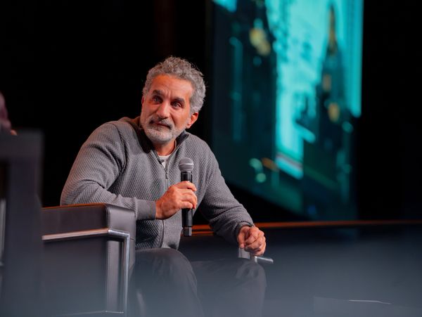 Man with gray hair holding a microphone during a talk or interview.