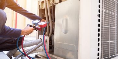 HVAC technician measuring refrigerant levels in an air conditioner