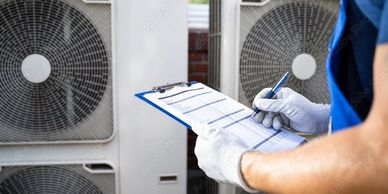 HVAC tech inspecting air conditioners