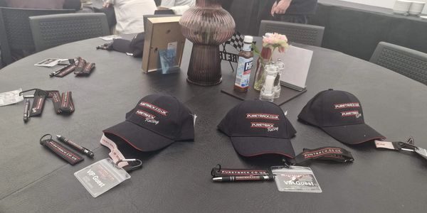 Caps, lanyards, and badges for an event on a round table.