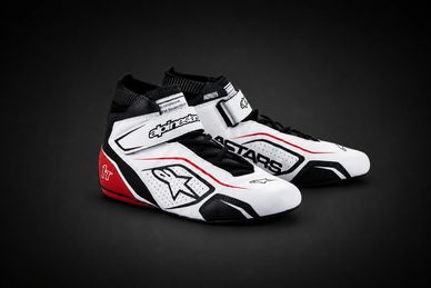 Sleek white, black, and red Alpinestars racing shoes with high ankle support and Velcro straps.