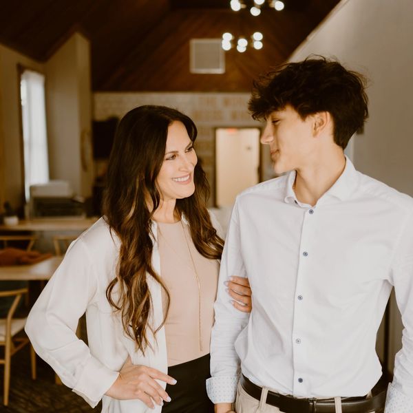 a women and a young man smiling at each other