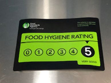 Food hygiene rating sticker on a stainless steel table