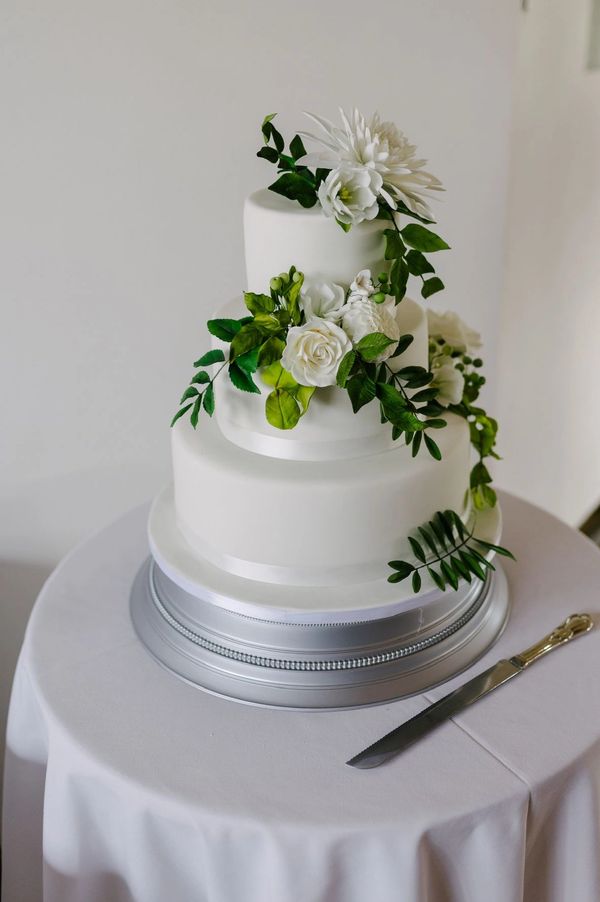 3 -tier white and green wedding cake with sugar lisianthus, roses, berries and foliage