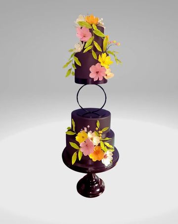 Black four tier wedding cake with colourful handmade sugar flowers black hoop separator and stand