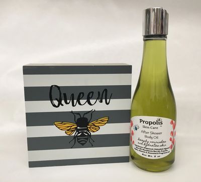Propolis body oil on display next to queen bee sign.