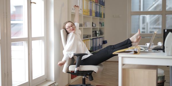 Woman sat in office with feet up on desk