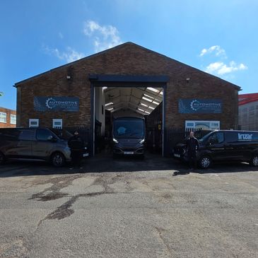 Automotive service garage with vans parked outside.