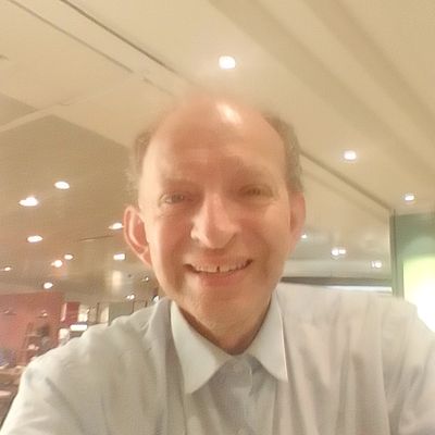 Man smiling in an indoor setting.