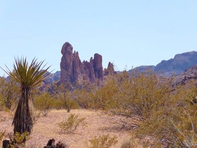 Desert landscape with unique rock formations and sparse vegetation under a clear sky.