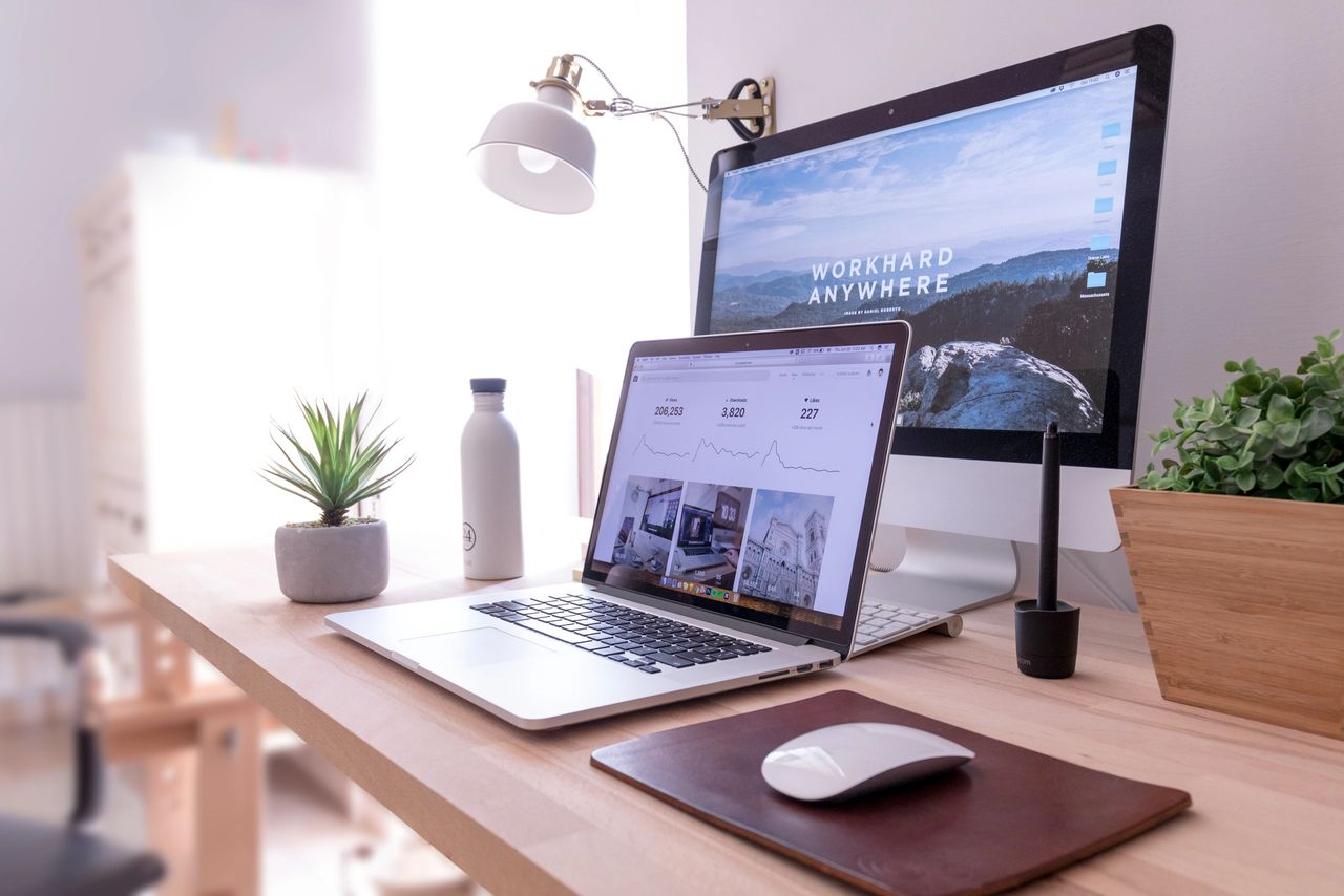 A desk with a laptop, extra monitor and mouse