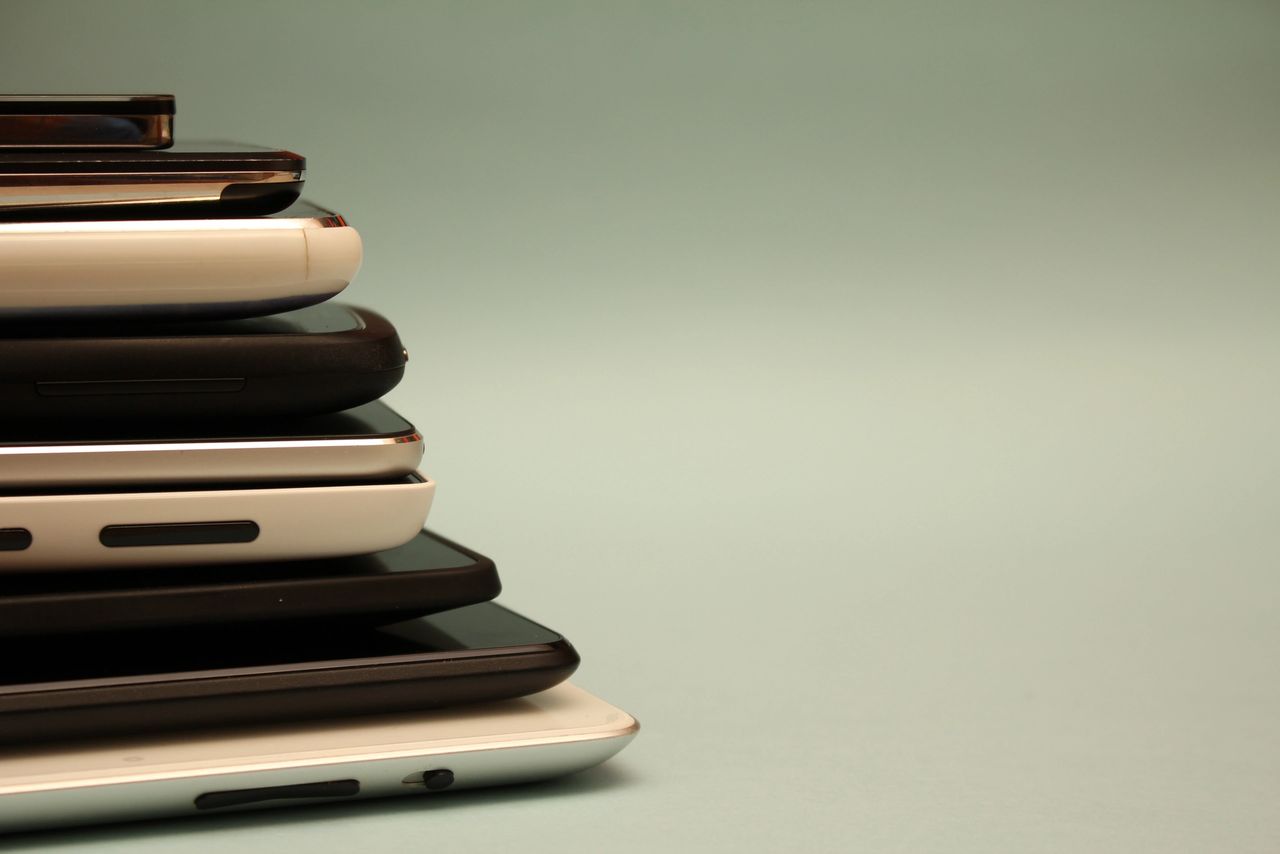 A stack of tablets and cellular phones.