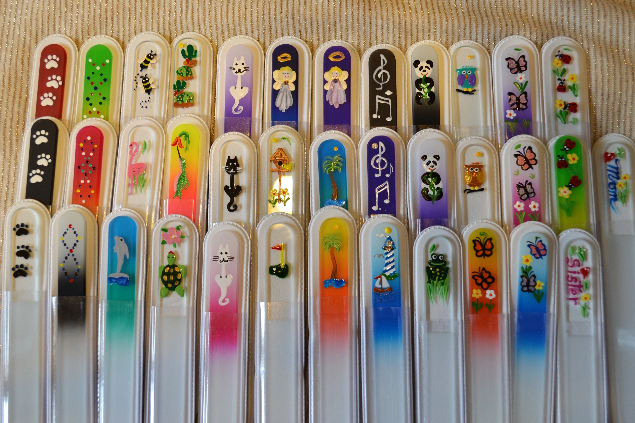 Many fun designs hand painted on various colors of Crystal glass fingernail files. 