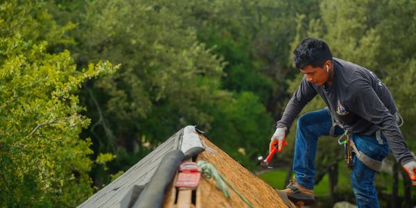 Expert roofer repairing a roof, ensuring durability. Quality roofing services in Austin. Hail Damage