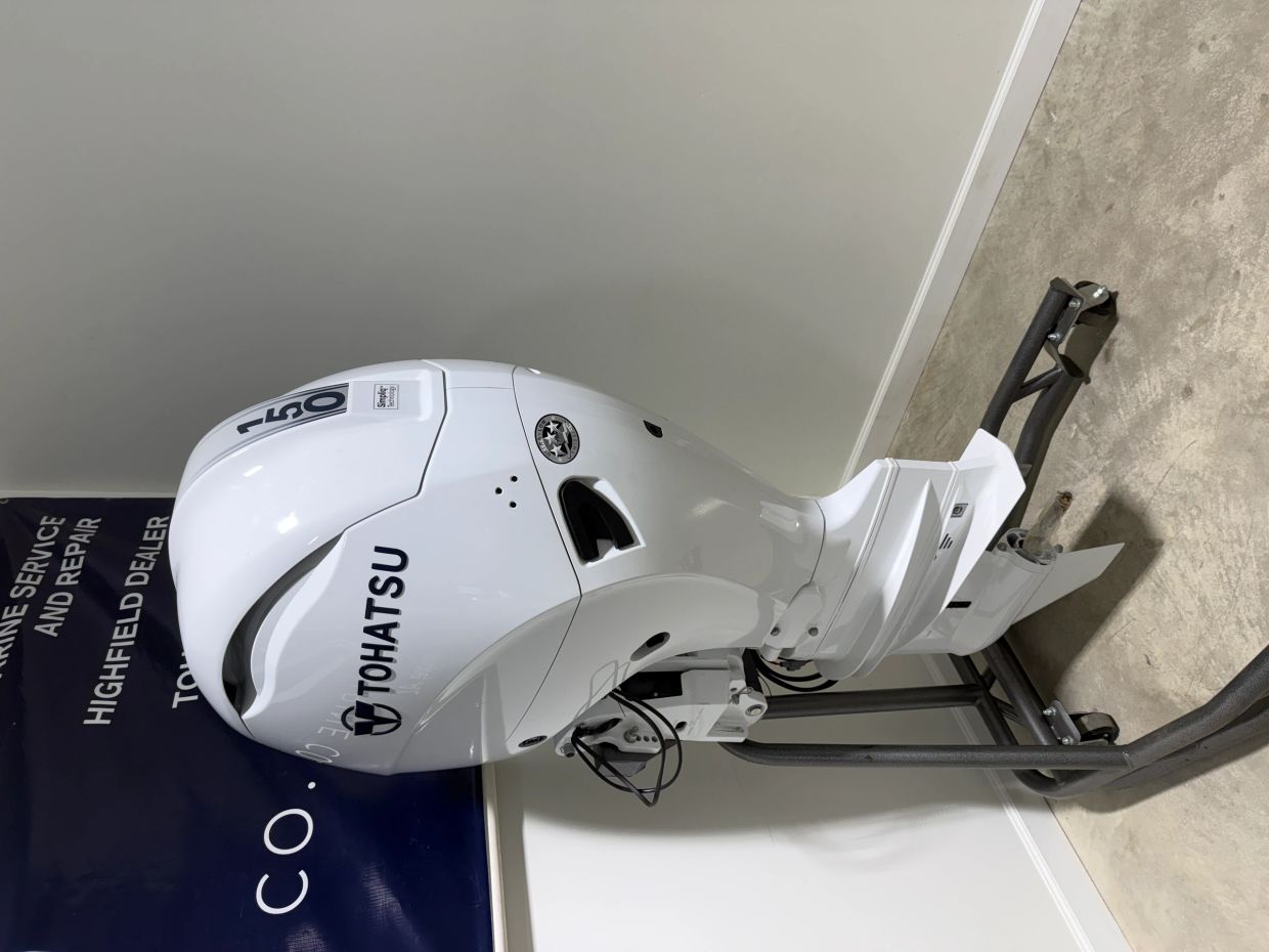 A white Tohatsu 150 horsepower outboard motor on a stand.
