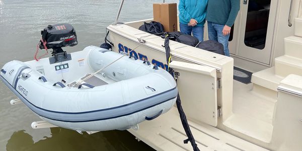 Small inflatable boat attached to a yacht.