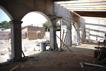 Construction site with arches and exposed beams in an unfinished building.