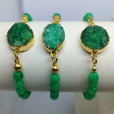 Green crystal bracelets with gold accents and beaded bands.
