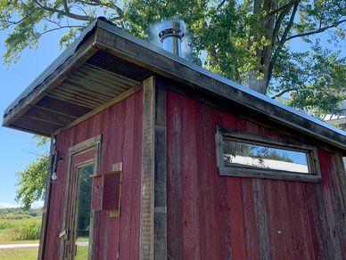 Rustic barnwood outdoor wood burning sauna built from reclaimed materials by No Boundaries Saunas.