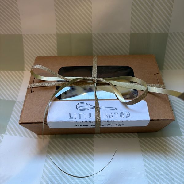 A gift box of homemade fudge tied with gold ribbon from Little Batch.