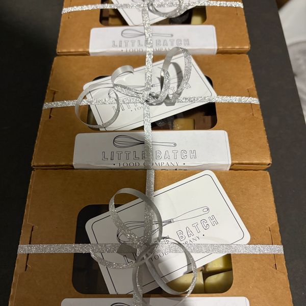 Three gift boxes from Little Batch Food Company tied with silver ribbon.