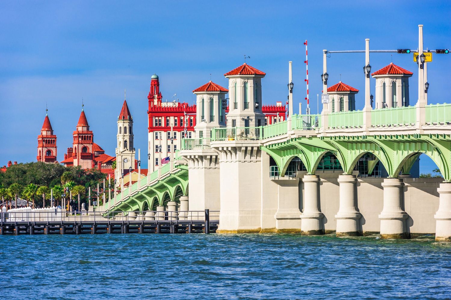 Historic bridge and red-roofed buildings by the waterfront.
