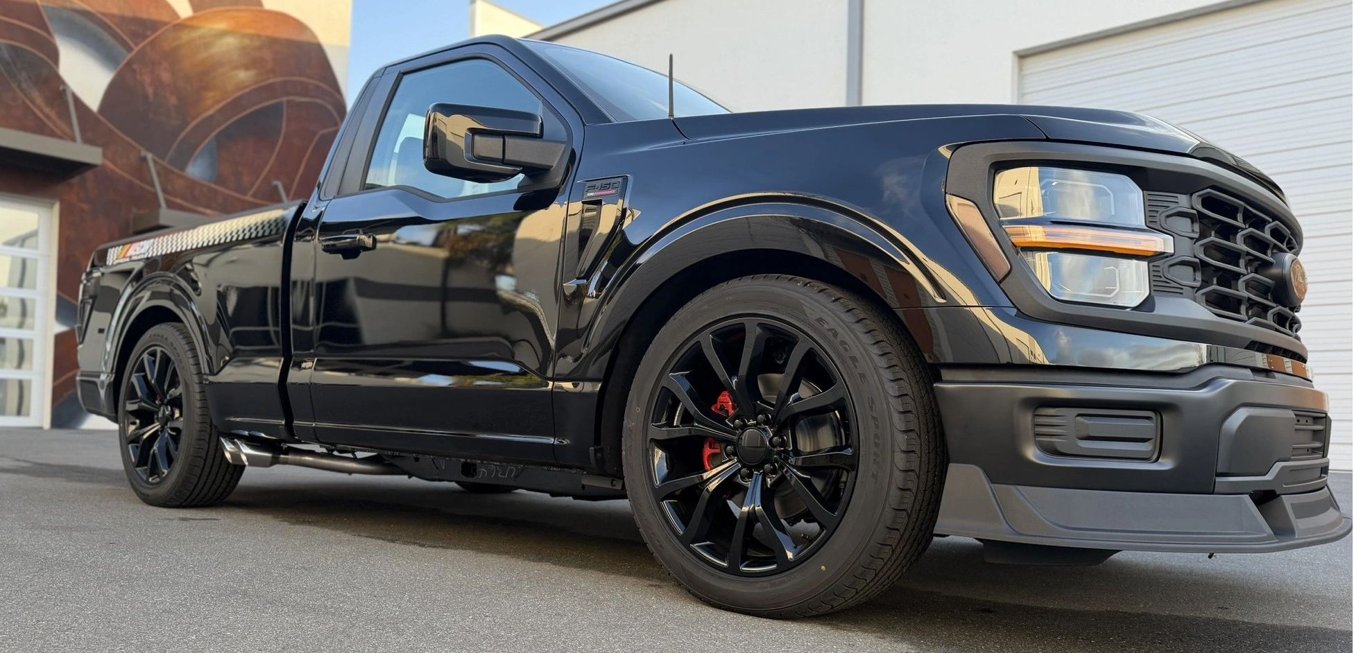 Sleek black Ford F-150 truck parked outside a modern building.