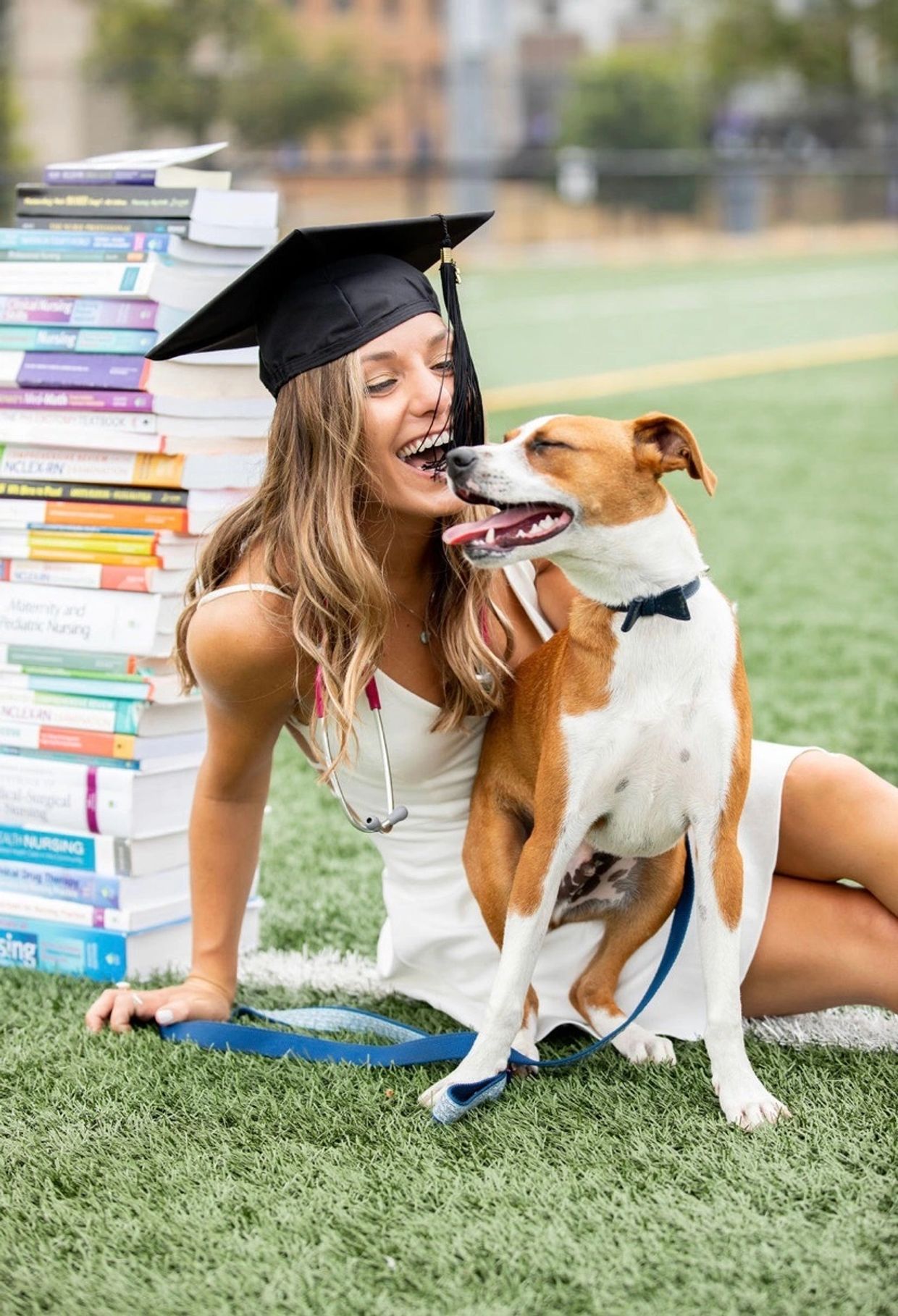Jessica Swarni, BSN, RN, with her dog beside nursing textbooks.