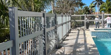 Metal fence around a pool casting shadows.