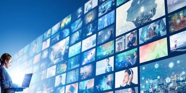 Person viewing numerous digital screens with various content.