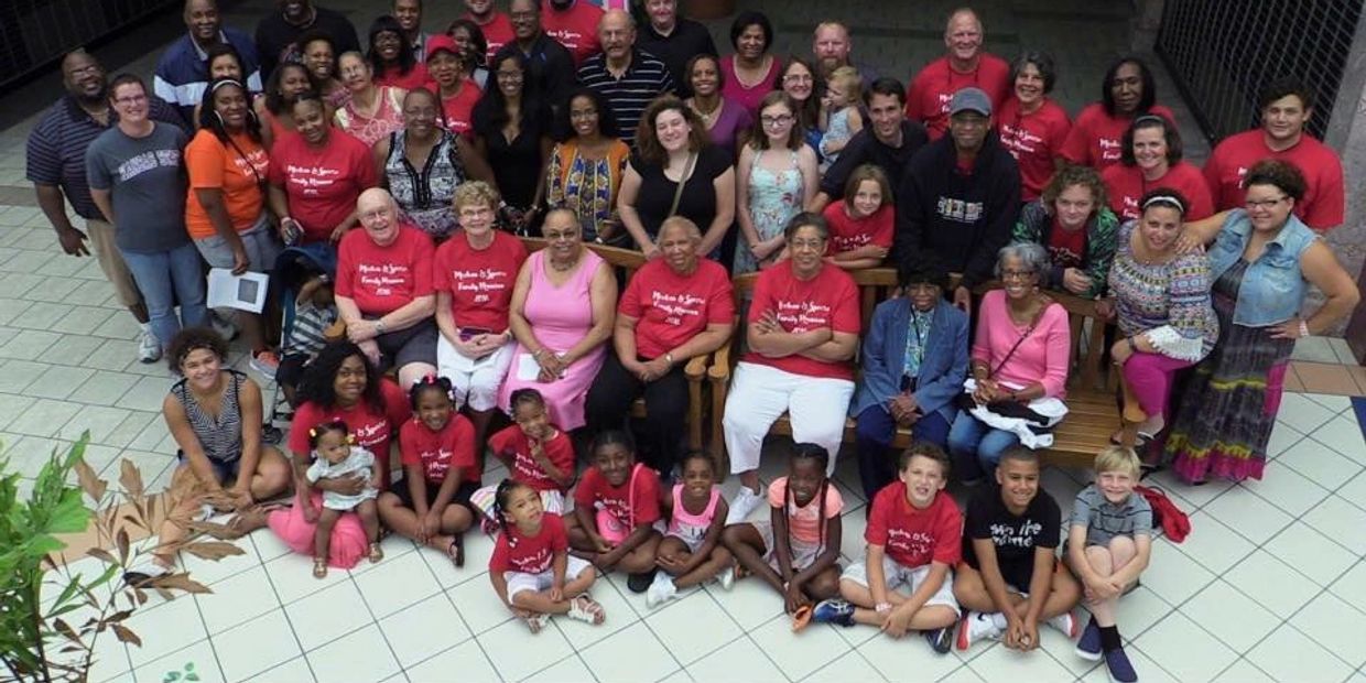 Large multigenerational family group photo in a mall atrium.