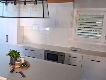 Modern white kitchen with sleek cabinets and a minimalist design.