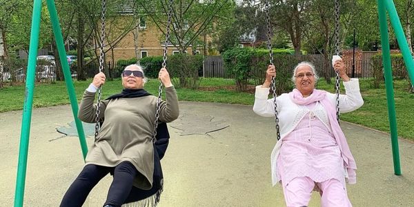 Elderly ladies from Nirvana Day Centre Slough on the swings in the park