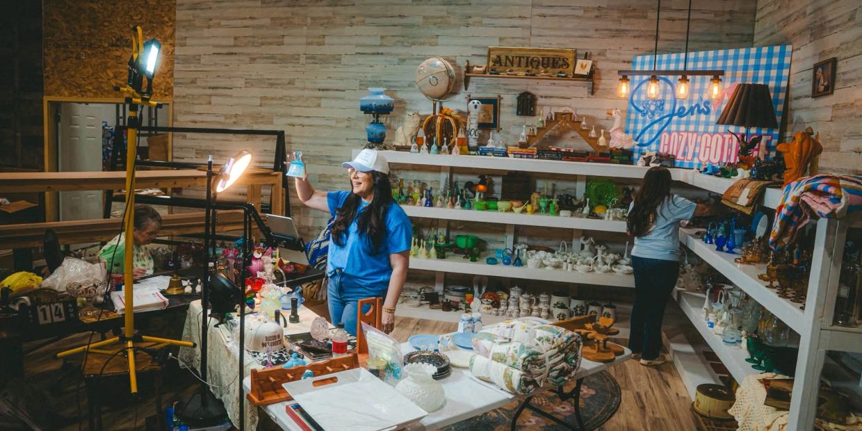 People shopping and arranging antiques in a cozy store.