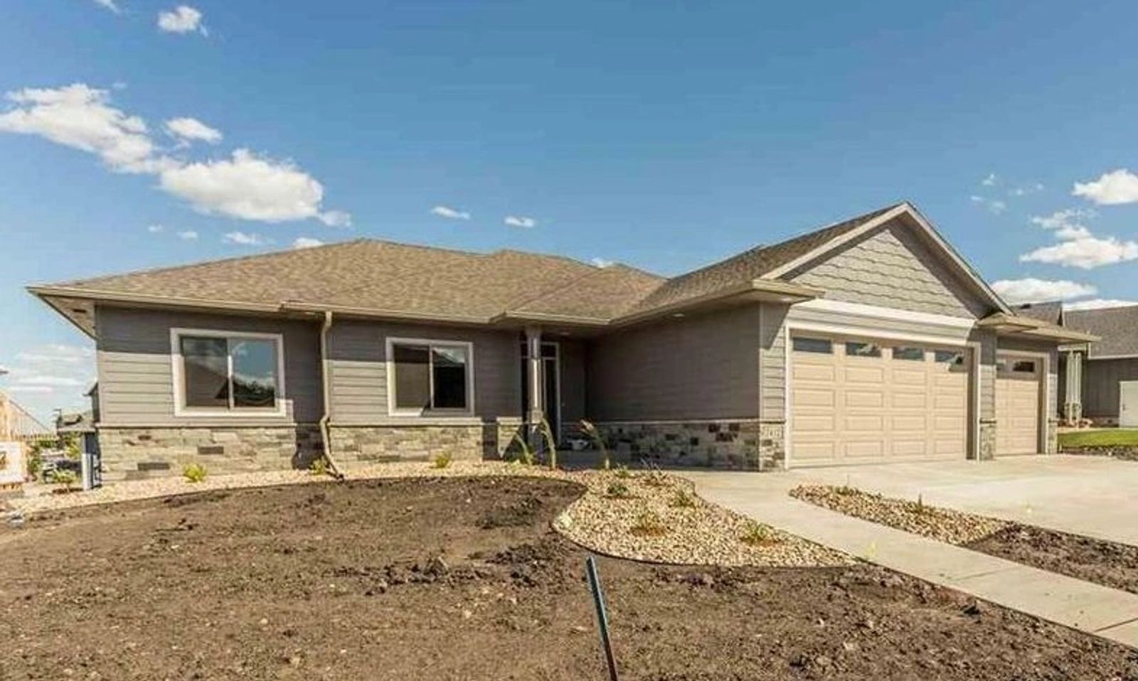 Custom home under construction in Sioux Falls with framing complete and roof sheathing in place